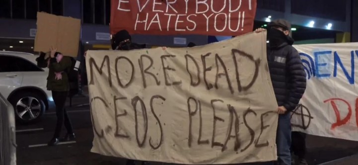 People in NYC holding banners during a CEO Event at Ziegfeld Ballroom